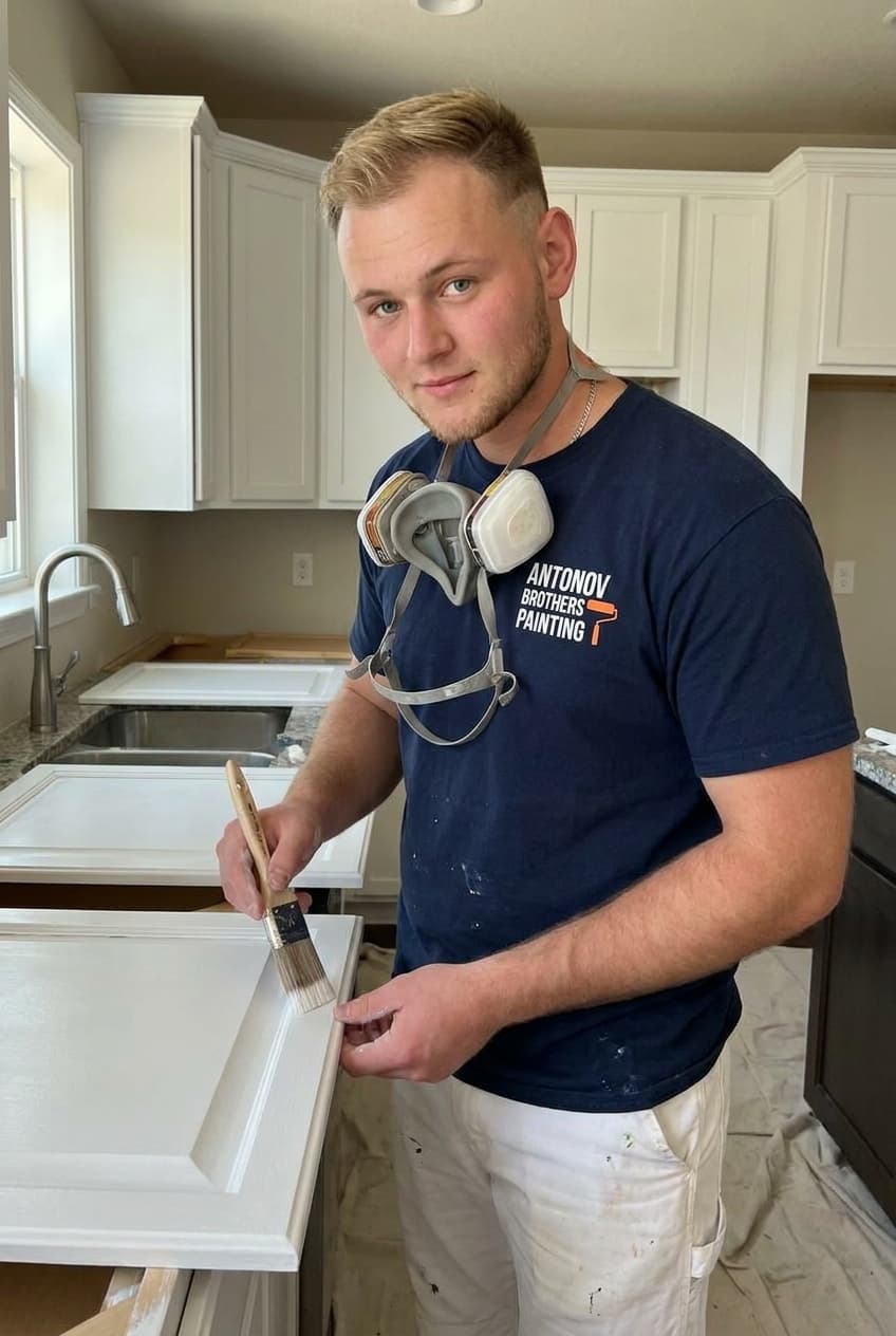 Antonov Brothers painter brushing a crisp white finish on a kitchen cabinet door