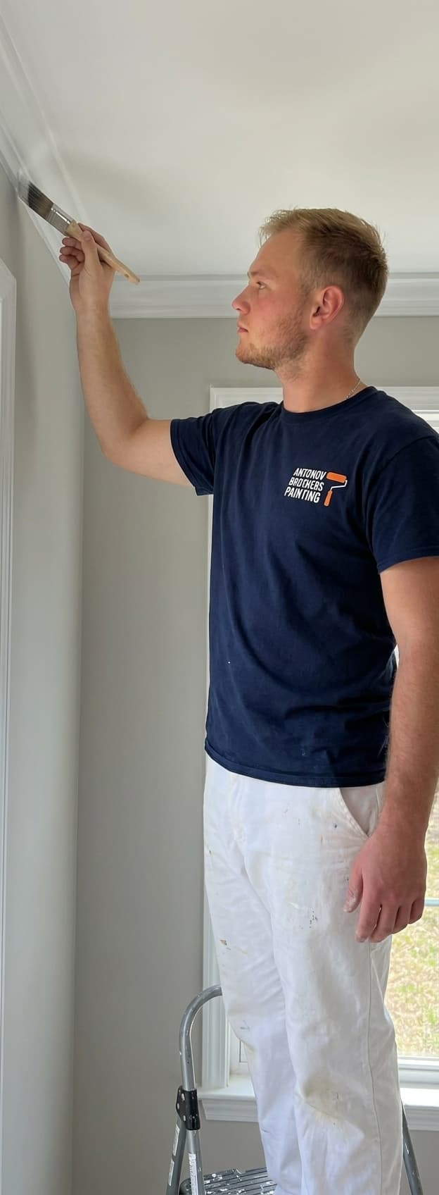 Cutting in a crisp paint line along crown molding — interior painting in Jacksonville